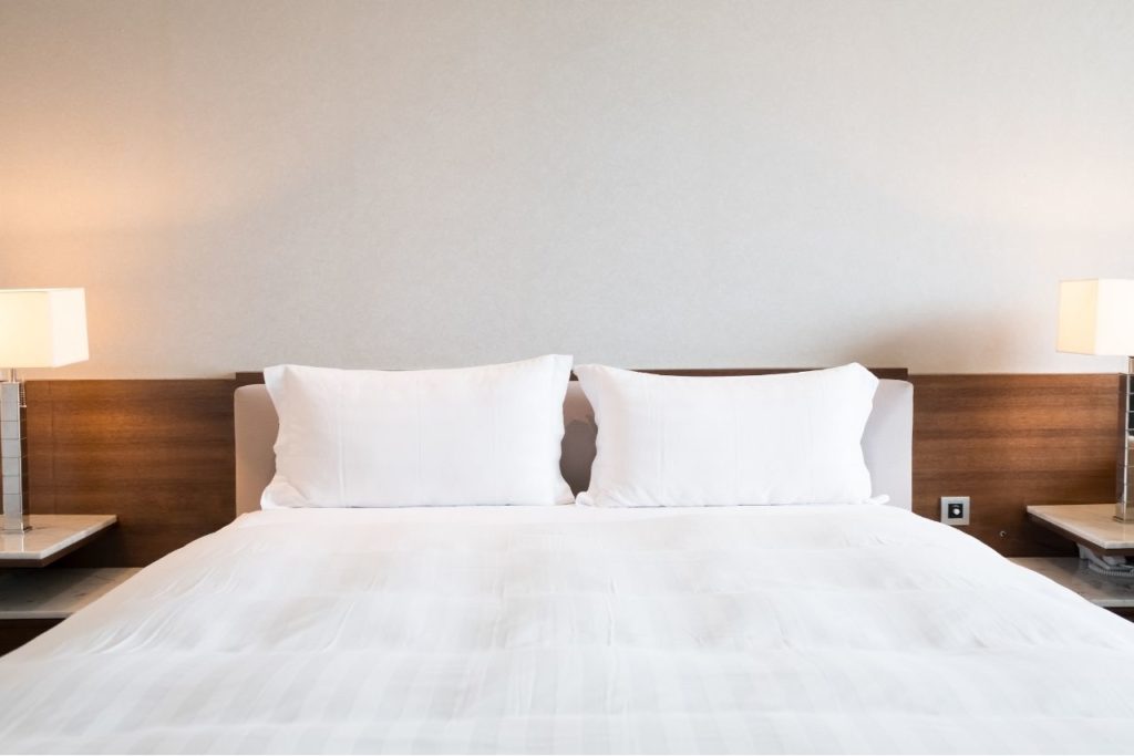 Doppelbett im Hotel mit weißer Bettwäsche
